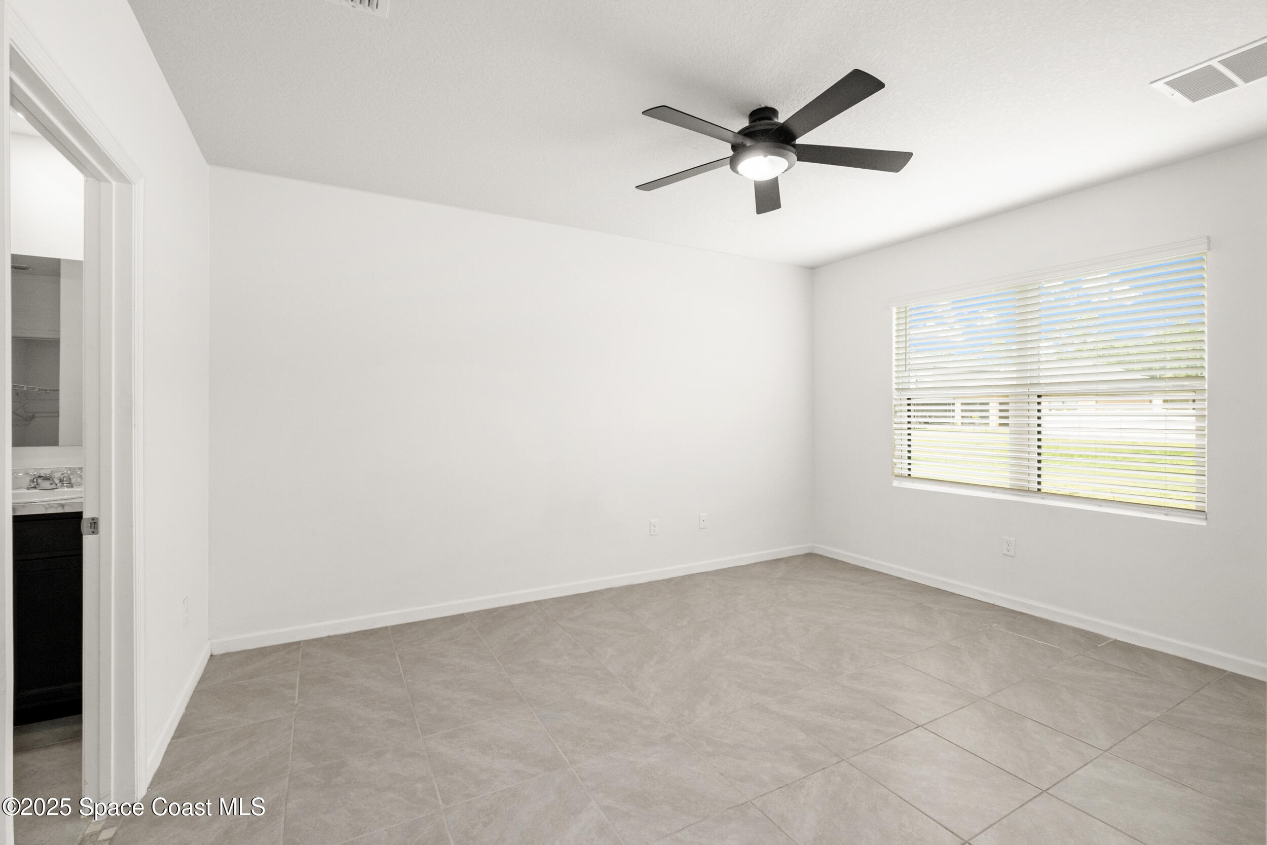 4641 Talbot Boulevard Cocoa, FL 32926 - Photo 6 of 14 an empty room with a ceiling fan and window