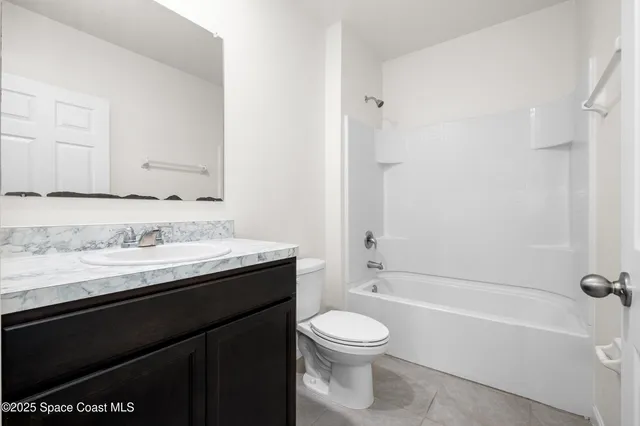 a bathroom with a granite countertop sink a toilet and bathtub