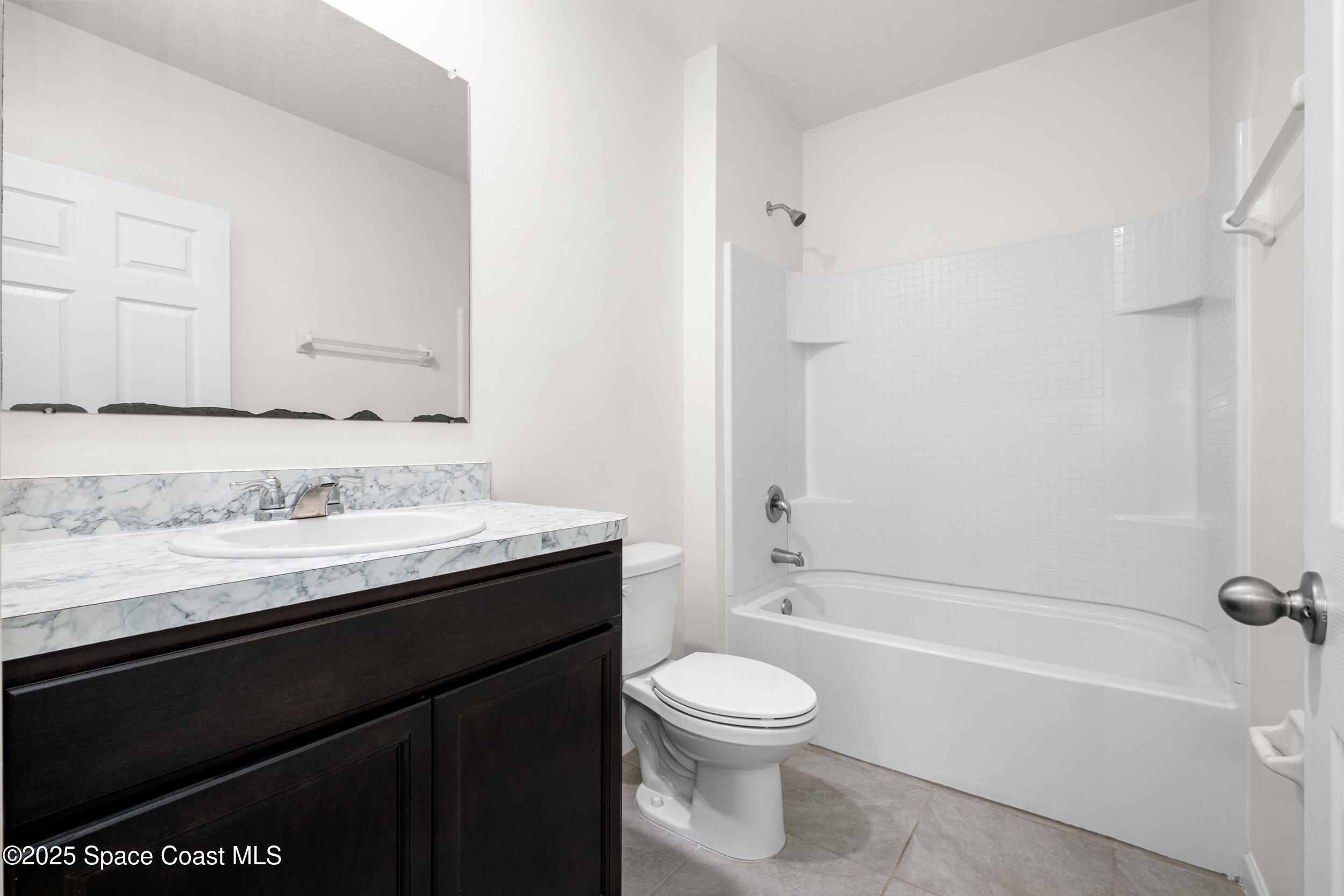 4641 Talbot Boulevard Cocoa, FL 32926 - Photo 10 of 14 a bathroom with a granite countertop sink a toilet and bathtub