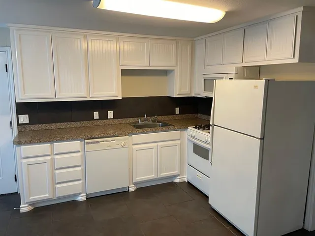 a white refrigerator freezer sitting inside of a kitchen