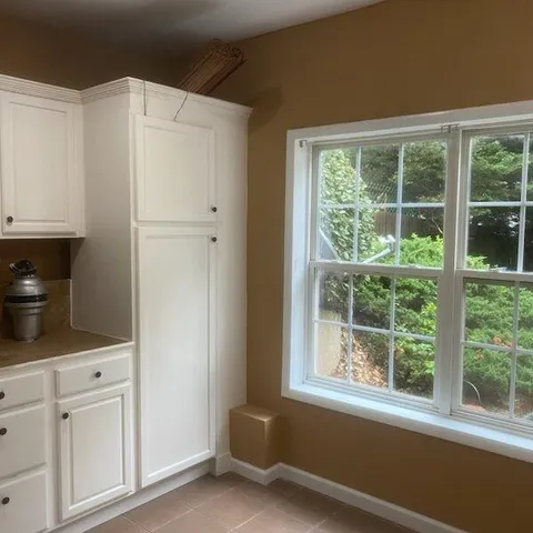 a kitchen with white cabinets and refrigerator