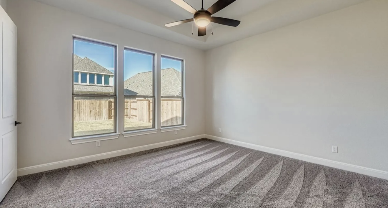 553 Prickly Poppy Loop Kyle, TX 78640 - Photo 8 of 11 an empty room with chandelier fan and windows