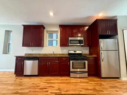 a kitchen with stainless steel appliances granite countertop a refrigerator stove and sink