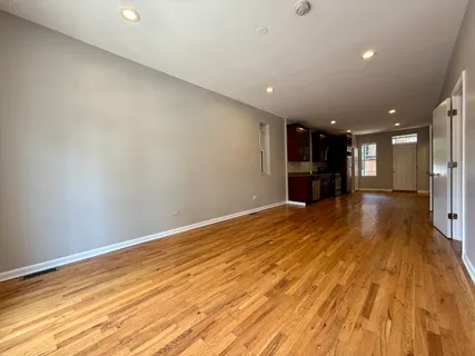 an empty room with wooden floor and a window