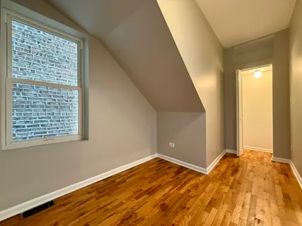 a view of a room with wooden floor and a window