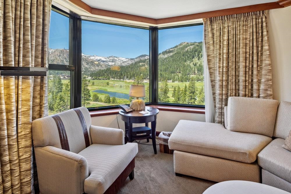 a living room with furniture and floor to ceiling windows