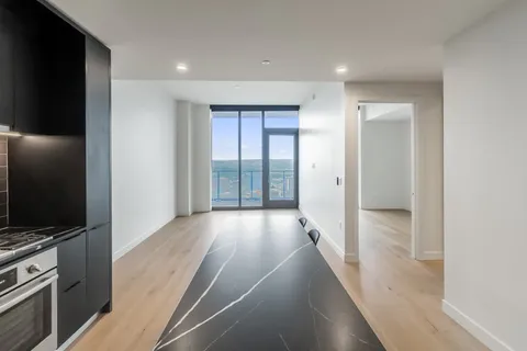 a view of a hallway with wooden floor and cabinet