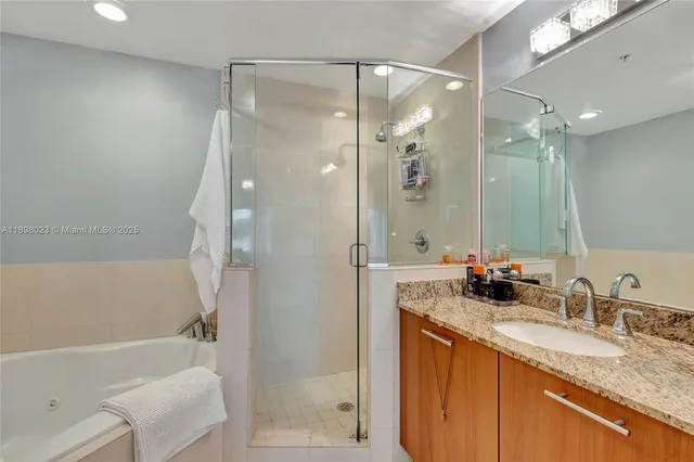 a bathroom with a granite countertop sink mirror toilet and bathtub