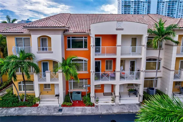 a front view of multiple houses with yard