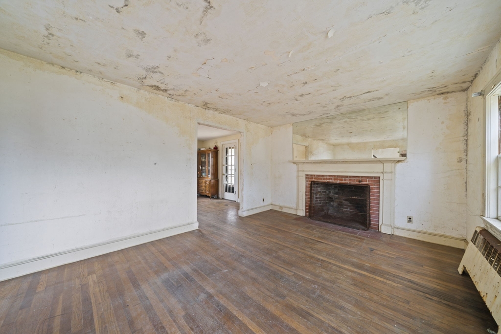 24 Butler Road Hingham, MA 02043 - Photo 10 of 38 a view of empty room with wooden floor and fireplace