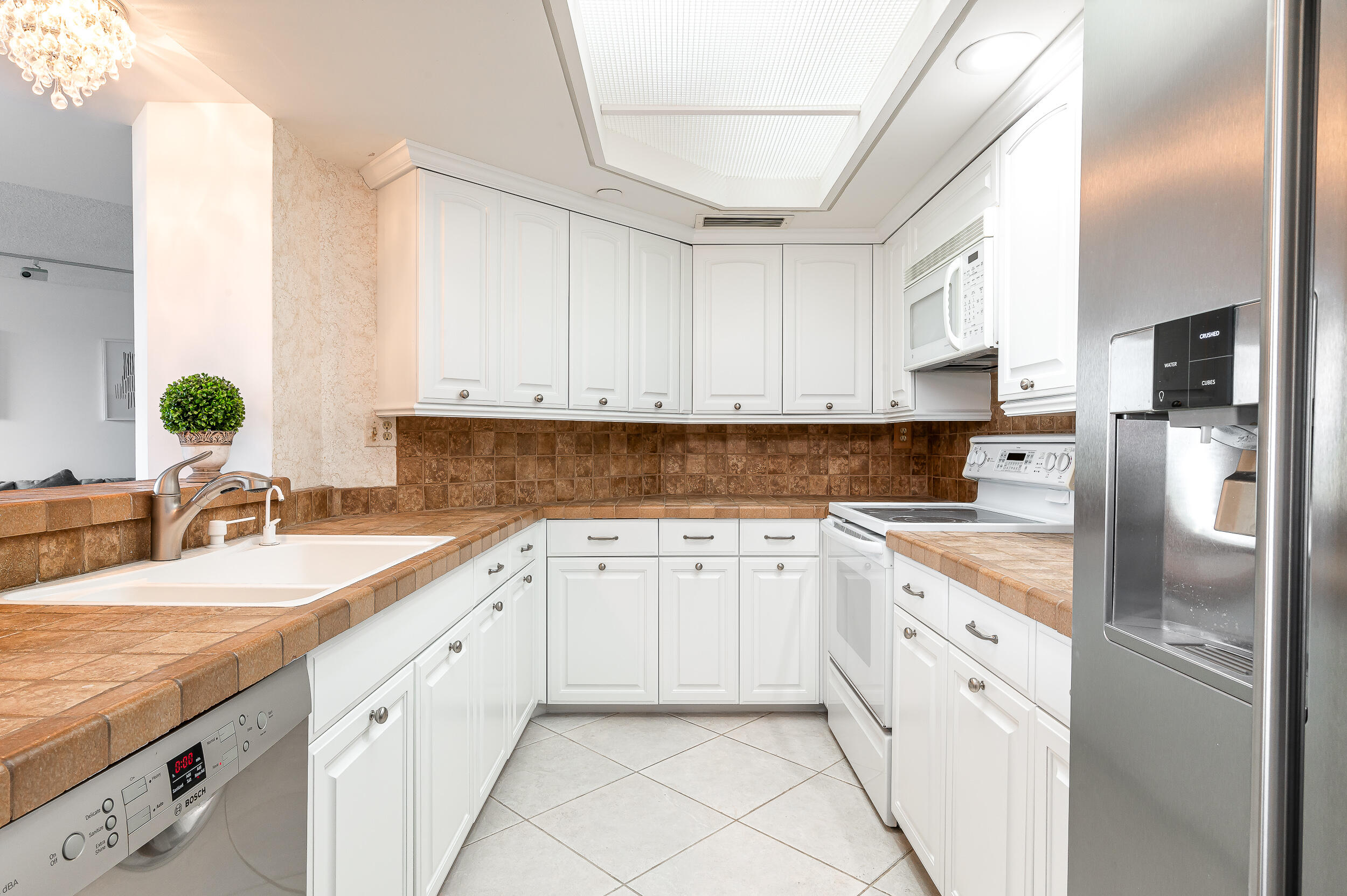 120 Southeast 5th Avenue, Unit PH22 Boca Raton, FL 33432 - Photo 7 of 32 a kitchen with granite countertop a sink stainless steel appliances and white cabinets