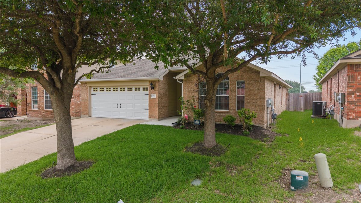 17812 Masi Loop Pflugerville, TX 78660 - Photo 4 of 38 Brick exterior featuring a two-car garage with paneling and windows
