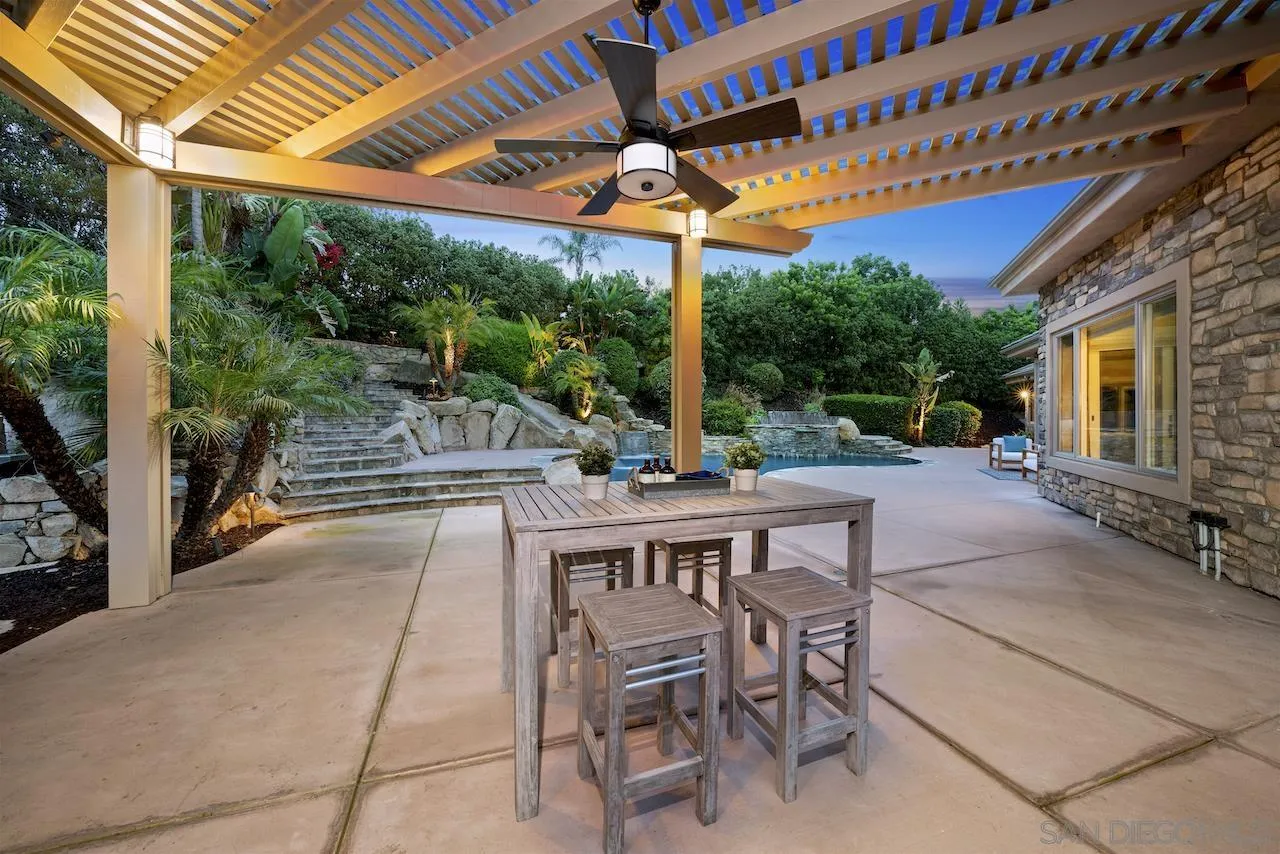 16644 Valle Verde Road Poway, CA 92064 - Photo 22 of 37 a view of a patio with a table and chairs under a large umbrella