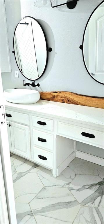 301 County Road Blossom, TX 75416 - Photo 12 of 19 Dual oval mirrors with matte black frames above a white vanity with integrated cabinetry