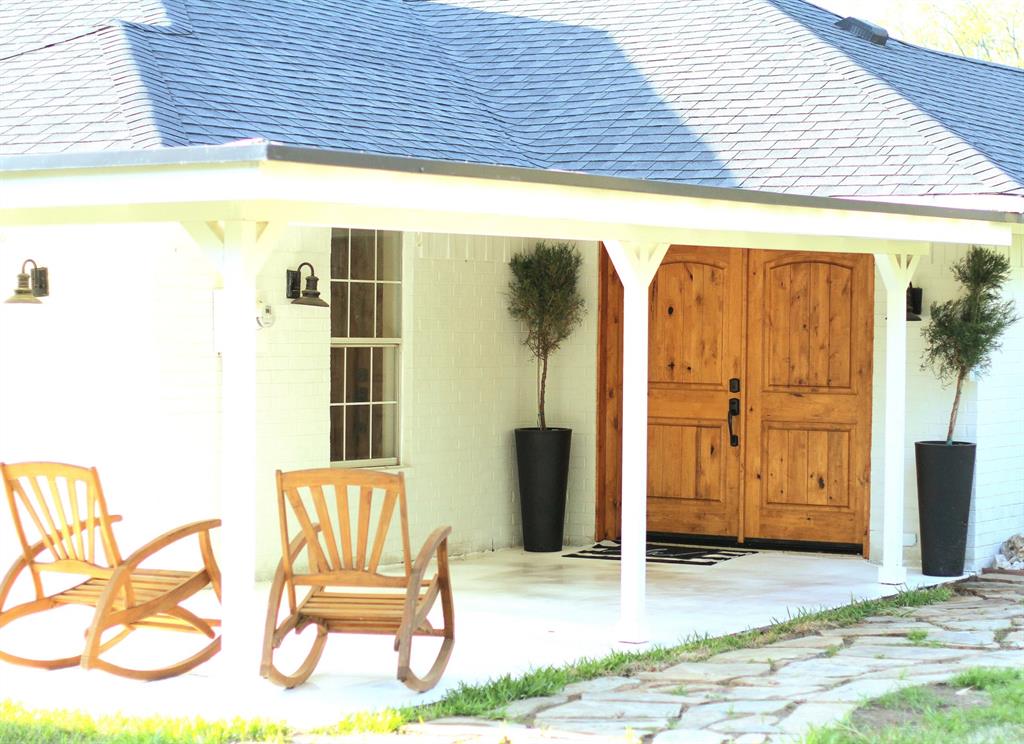 301 County Road Blossom, TX 75416 - Photo 4 of 19 White brick exterior featuring a covered porch with a light-colored concrete surface