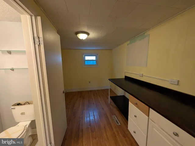 a kitchen with wooden floor and a black white refrigerator
