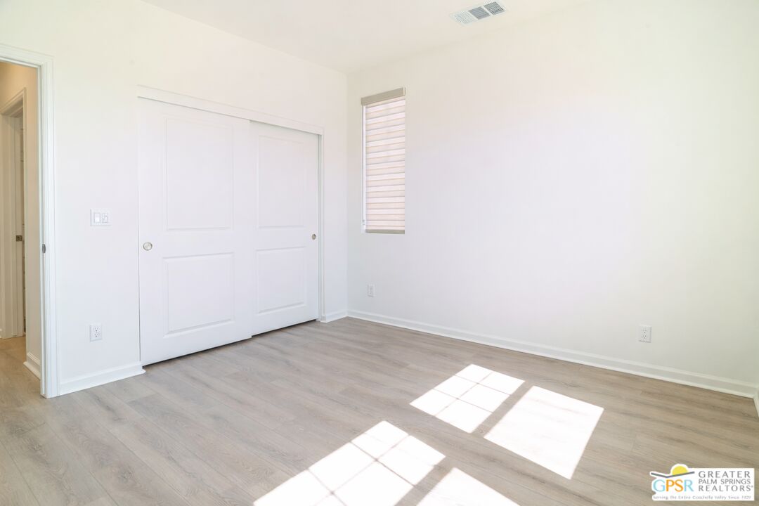78924 Santa Rosa Way Palm Desert, CA 92211 - Photo 11 of 71 an empty room with wooden floor and windows