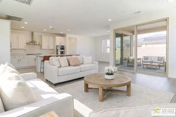 a living room with furniture and a floor to ceiling window