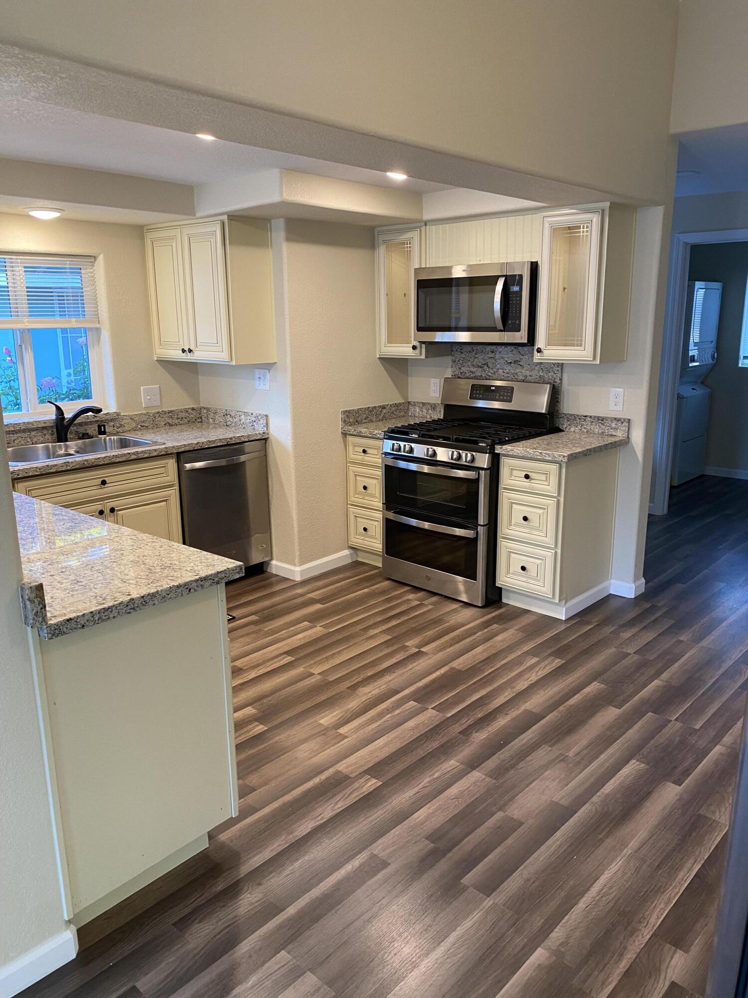 2180 El Reno Lane Redding, CA 96001 - Photo 10 of 39 a kitchen with stainless steel appliances kitchen island granite countertop a stove and a sink