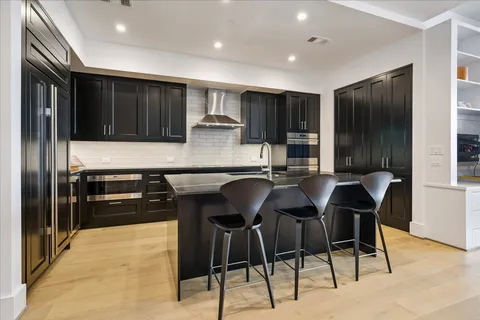 a kitchen with a table chairs refrigerator and cabinets