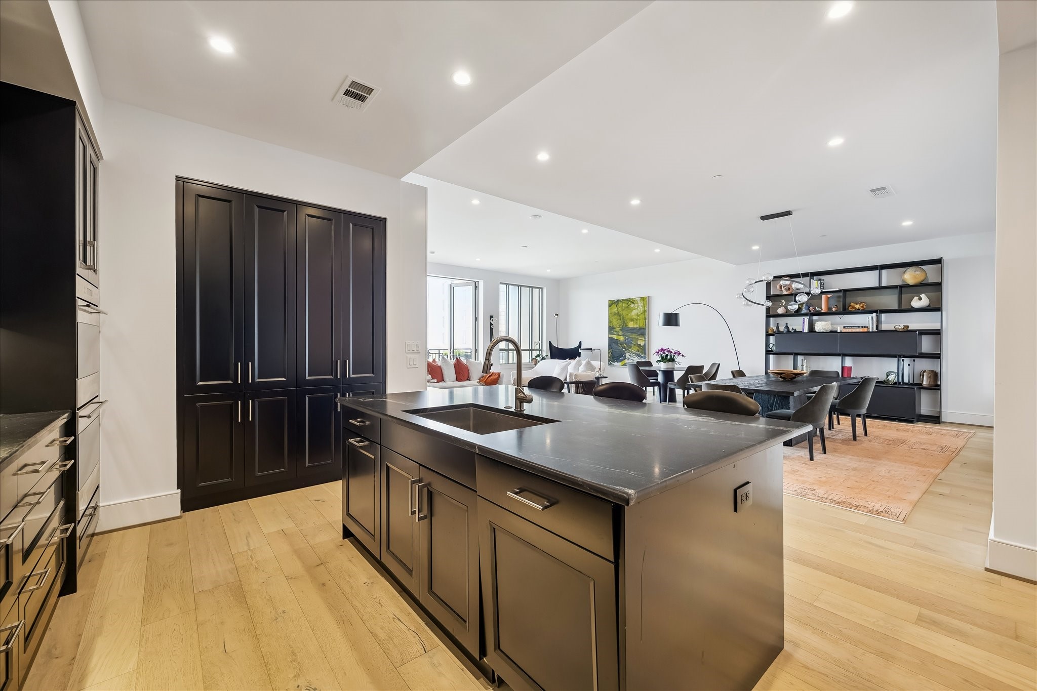 2325 Welch Street, Unit 704 Houston, TX 77019 - Photo 13 of 33 A sophisticated culinary space complete with double wall ovens, induction cooktop, and built-in wine storage. Open to the main living areas, it’s ideal for hosting with ease.