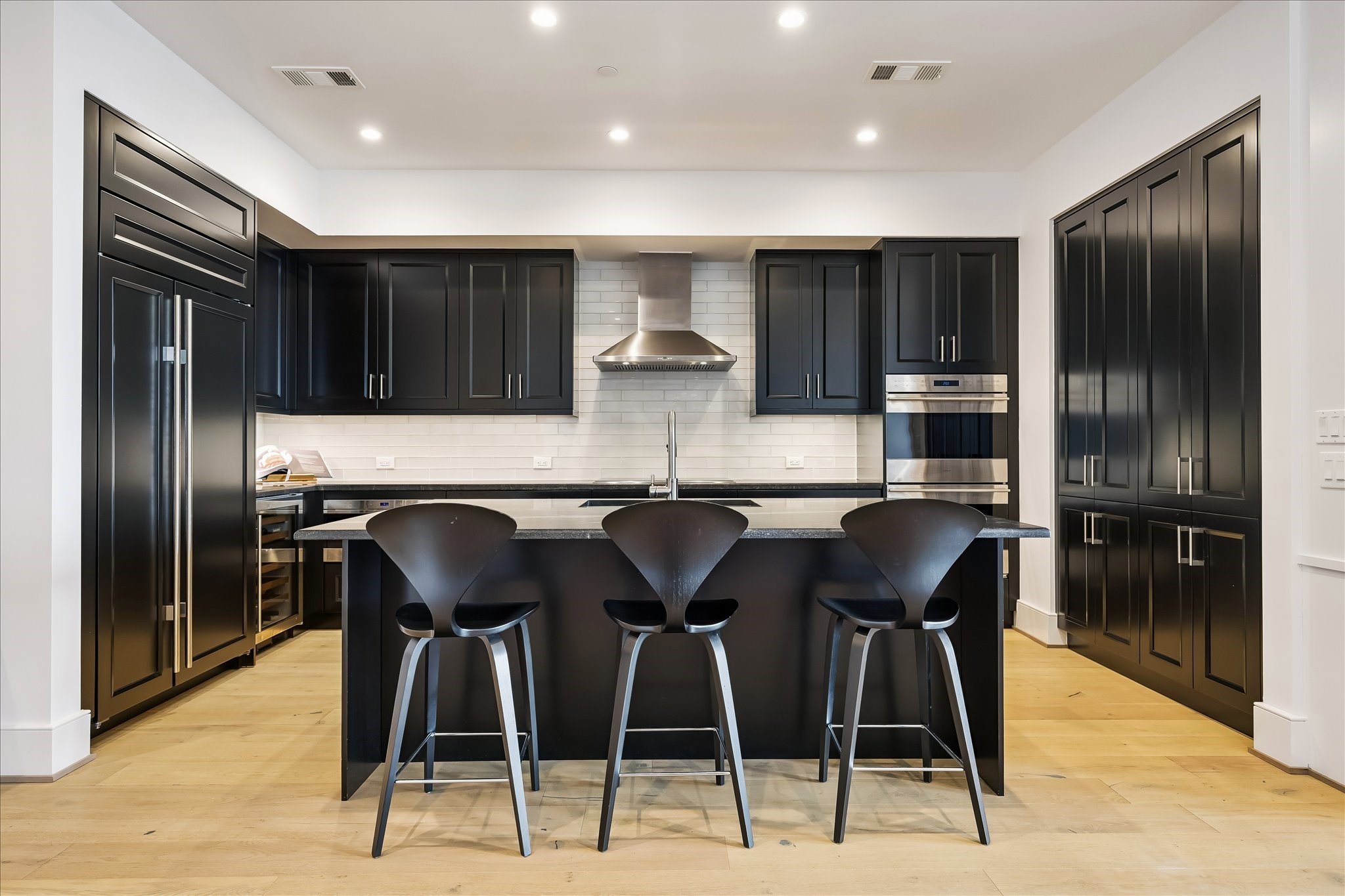 2325 Welch Street, Unit 704 Houston, TX 77019 - Photo 14 of 33 Elevated design meets top-tier performance with a full suite of Sub-Zero, Wolf, and Asko appliances. Clean lines, under-cabinet lighting, and a spacious island create a refined yet highly functional workspace.