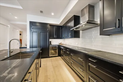 a kitchen with kitchen island granite countertop a sink stainless steel appliances and cabinets