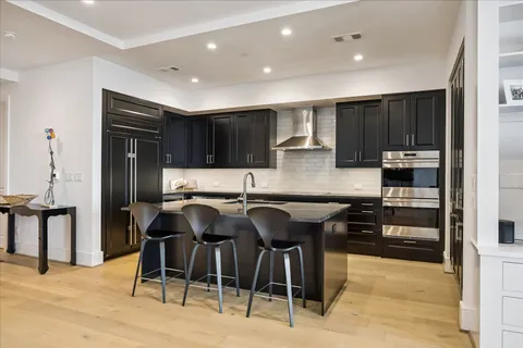 a kitchen with stainless steel appliances granite countertop table chairs microwave and sink