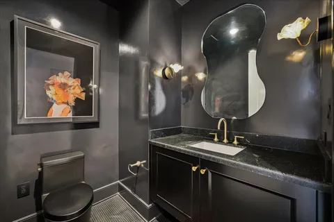 a bathroom with a toilet sink and mirror