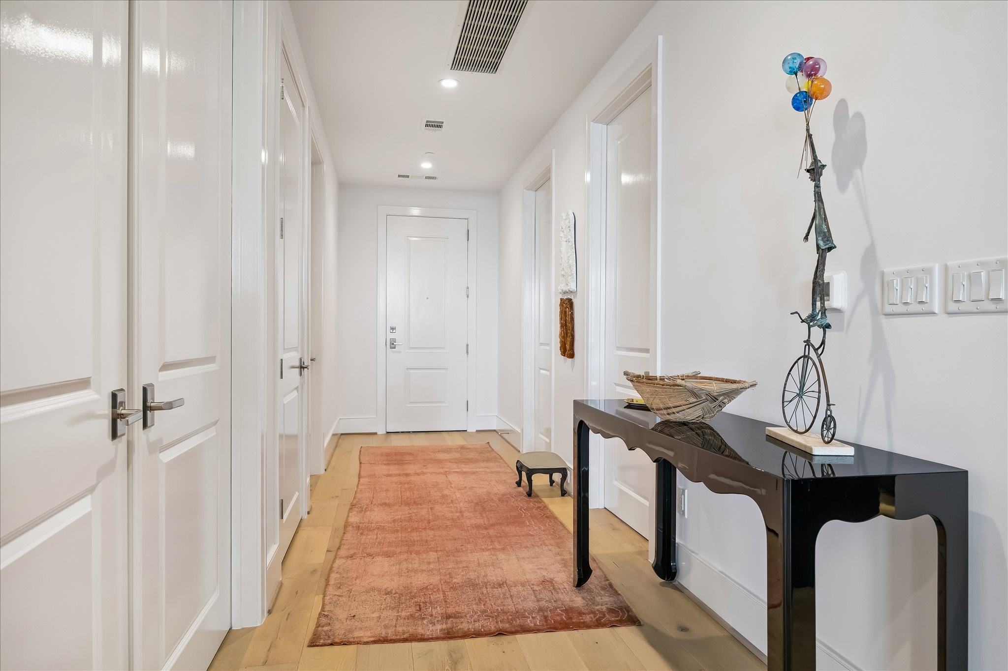 2325 Welch Street, Unit 704 Houston, TX 77019 - Photo 3 of 33 A welcoming entry with wide plank white oak floors and soft designer tones sets the stage for the home. Recessed lighting and a thoughtfully designed layout offer seamless access to the powder room, utility room, and coat closet.