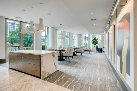 a large living room with stainless steel appliances granite countertop furniture a large window and a chandelier