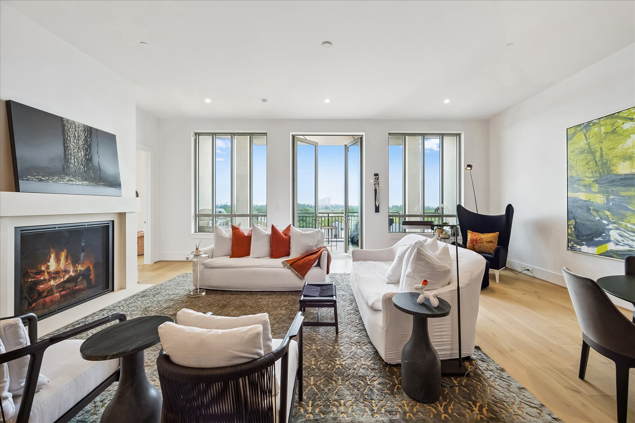 2325 Welch Street, Unit 704 Houston, TX 77019 - Photo 4 of 33 Designed for comfort and connection, the living room features expansive windows, warm wood floors, and seamless flow to the kitchen and dining areas. A perfect setting for relaxing or entertaining.