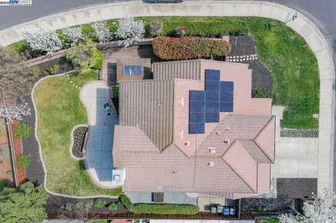 an aerial view of a house with a yard and large trees