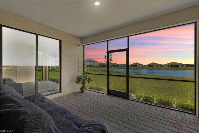 a bedroom with a bed and large windows