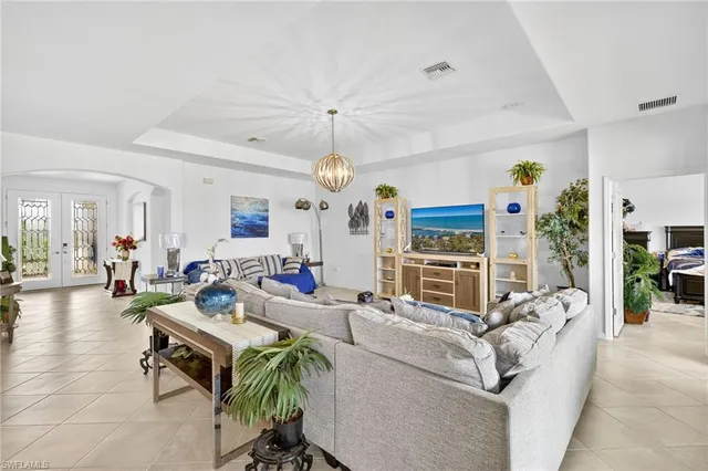 a living room with furniture a dining table and a chandelier