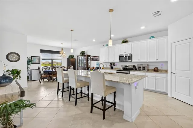 a kitchen with kitchen island granite countertop cabinets and chairs