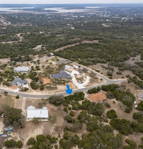 an aerial view of residential houses with outdoor space and trees