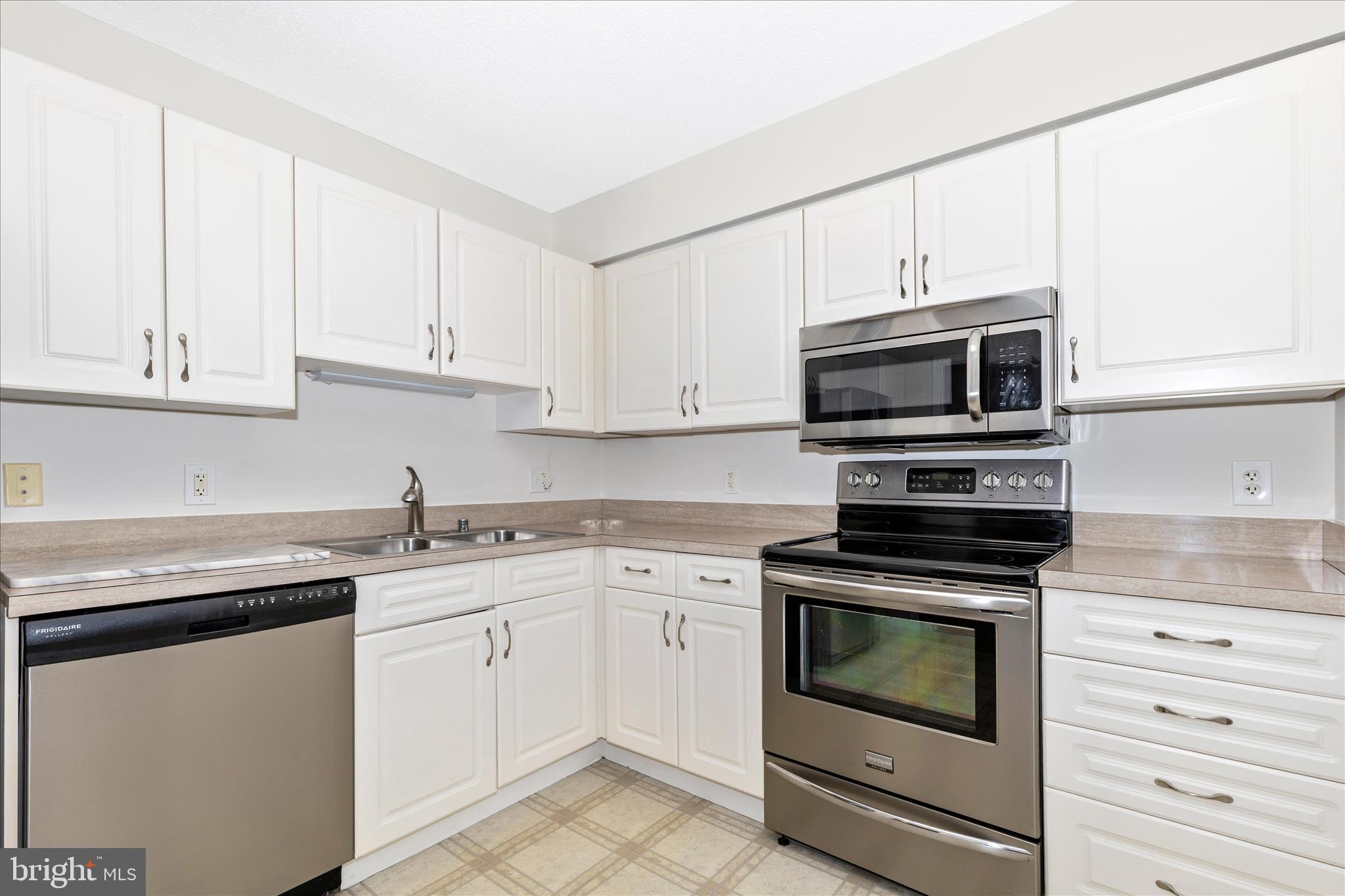 14809 Pennfield Circle, Unit 309 Silver Spring, MD 20906 - Photo 3 of 64 a kitchen with cabinets stainless steel appliances and sink