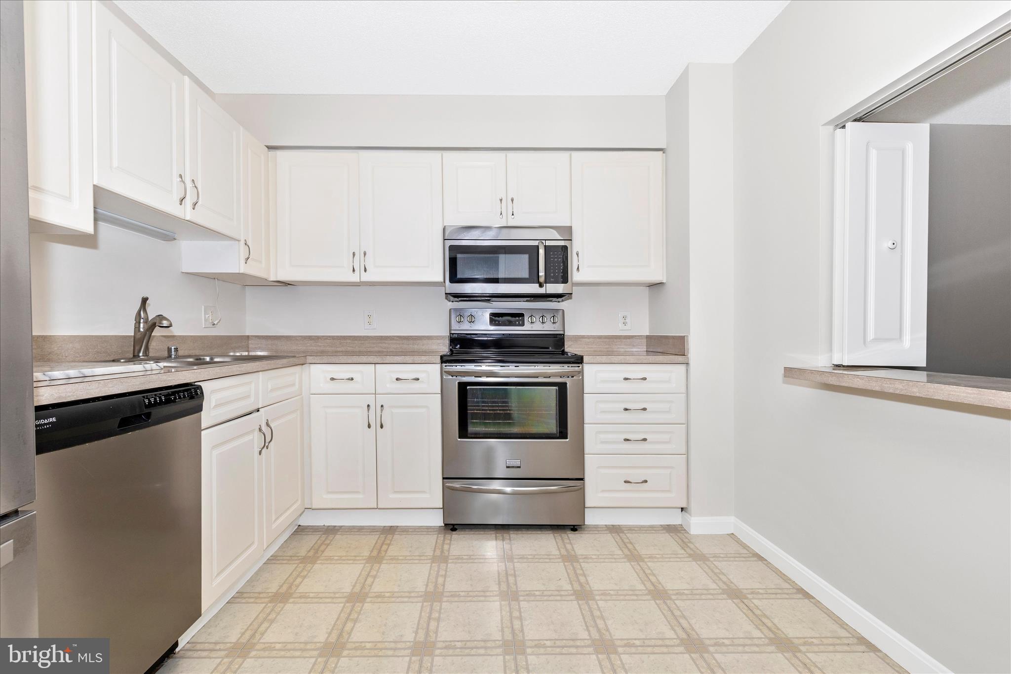14809 Pennfield Circle, Unit 309 Silver Spring, MD 20906 - Photo 7 of 64 a kitchen with cabinets stainless steel appliances and counter space