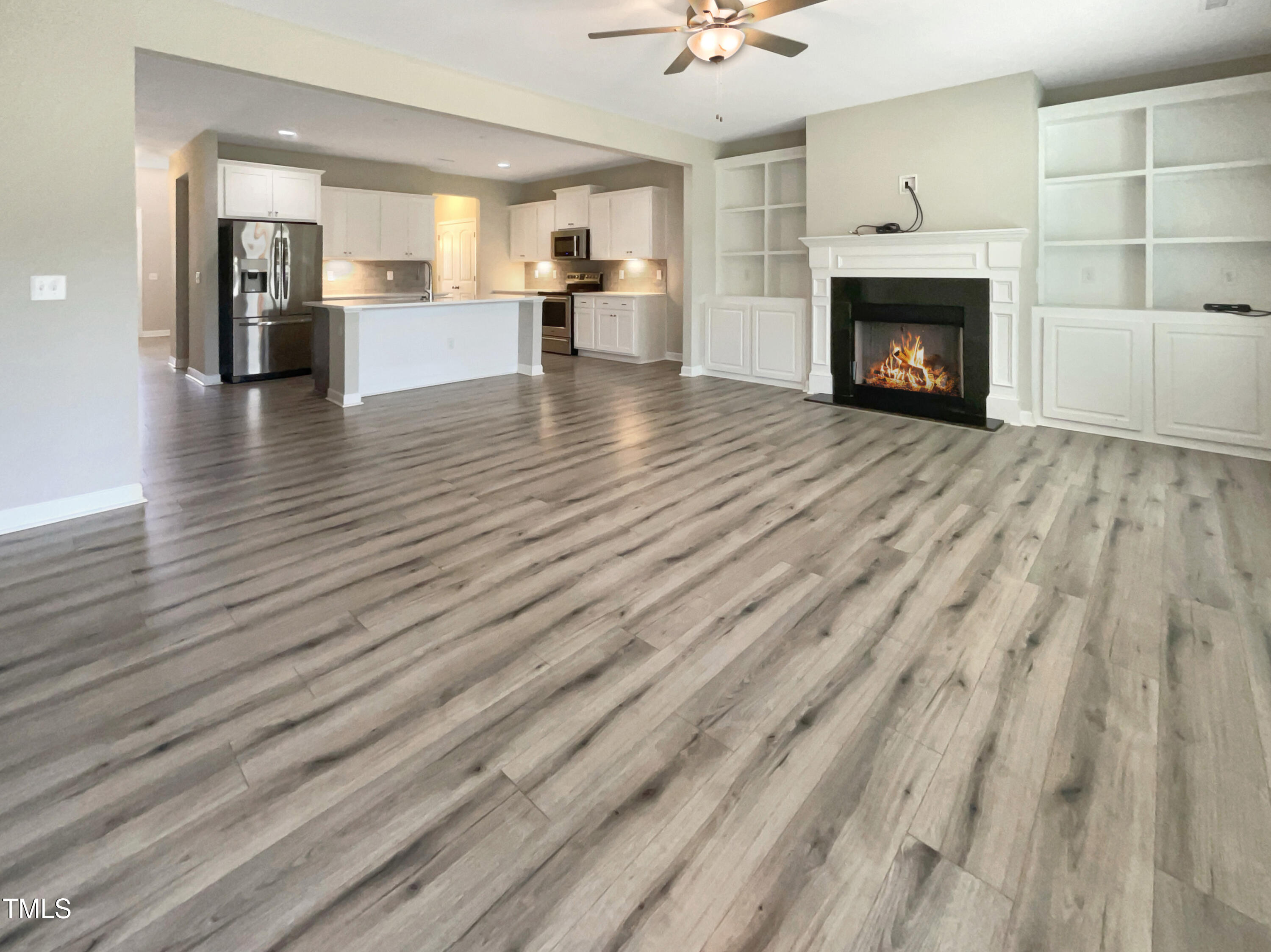 197 Steep Rock Drive Willow Spring, NC 27592 - Photo 19 of 20 a view of empty room with wooden floor and fireplace