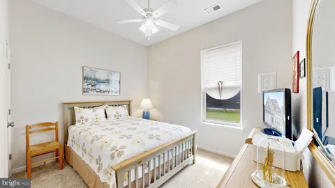 a bedroom with a bed a mirror on the wall and a window