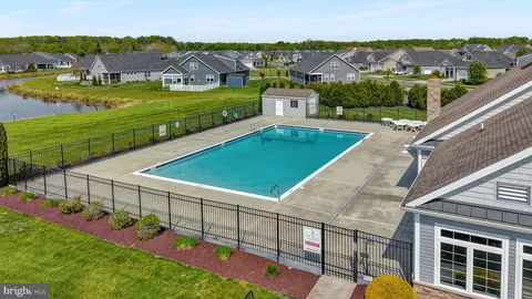 an aerial view of residential houses with outdoor space and trees