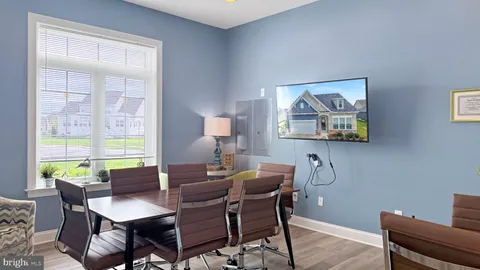 a living room with furniture a flat screen tv and large windows