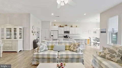 a large living room with stainless steel appliances kitchen island granite countertop furniture and a rug