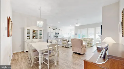 a dining room with furniture a chandelier and wooden floor