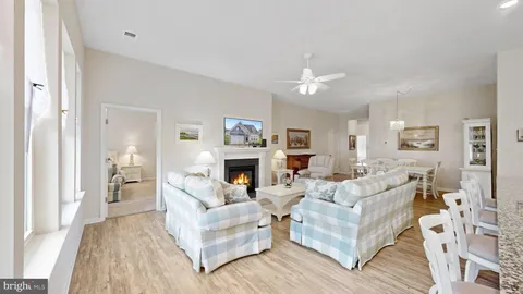 a living room with furniture a fireplace and a chandelier