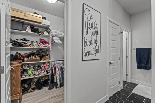 a view of walk in closet with clothes and shoes