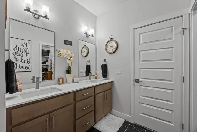 a bathroom with a double vanity sink and a mirror