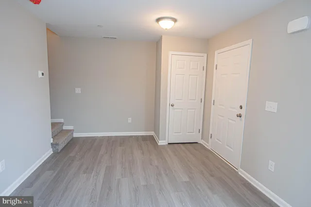 a view of a big room with wooden floor and windows