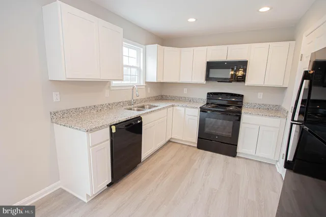 wooden floor in an empty room with a kitchen